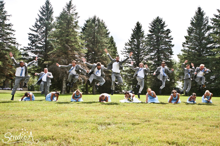 crazy jumping photo wedding groomsmen over bridesmaids 